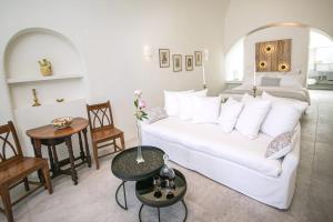 salon z białą kanapą i stołem w obiekcie Elegant Santorini Villas Villas Aloia Private Hot Tub Air Conditioning 1 Bedrooms Oia w mieście Oia +24 zdjęcia