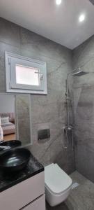 a bathroom with a toilet and a sink and a shower at PLATINUM ApartmentsINNThebeach in Vlorë