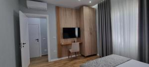 a bedroom with a bed and a television on a wall at PLATINUM ApartmentsINNThebeach in Vlorë