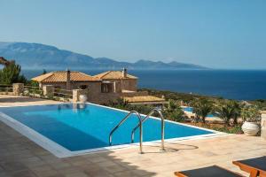 a swimming pool in front of a house with the ocean at Luxury Zakynthos Villa Villa Leona 2 Bedrooms Agios Nikolaos in Zakynthos Town