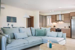 a living room with a blue couch and a kitchen at Deluxe Kefalonia Apartment Apartment Ammos 3 Bedroom Pool Sea View Karavomilos in Karavomylos