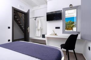 a bedroom with a bed and a chair and a window at Charming Santorini Villa 2 Bedrooms Premium Villa Private Heated Pool & Refined Interior Perissa in Perissa