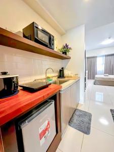 a kitchen with a counter top with a microwave at Cozy Space at Horizons 101 Cebu City with Pool, Netflix, Wifi in Cebu City