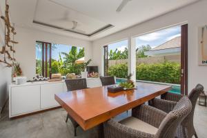 een keuken en eetkamer met een houten tafel en stoelen bij Gajah Villas Bali by Nagisa Bali in Seminyak