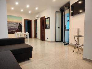 una sala de estar con un sofá y una mesa en CconfortHotels eXtramurale Apartment, en Bari