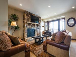 een woonkamer met 2 banken en een stenen open haard bij Fairway Springs by Park City Vacations in Park West Ski Area Heliport