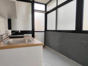 cocina con fregadero y algunas ventanas en CconfortHotels eXtramurale Apartment, en Bari
