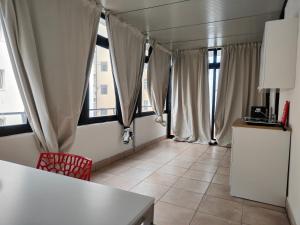 Habitación con cortinas, mesa y nevera. en CconfortHotels eXtramurale Apartment, en Bari