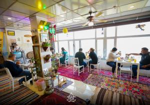 a group of people sitting at tables in a restaurant at Vote Hotel 1 in Erbil +20 photos