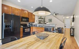 a kitchen with a wooden table and a black refrigerator at Lovely 3bd Home With Bbq in Orlando