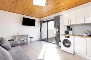 a living room with a couch and a kitchen at Home2Book Serene Stay & Sea View Terrace in Arico in La Mareta
