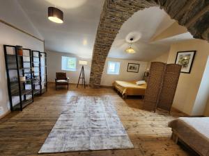 a bedroom with a bed and a room with a brick wall at Gîte Le Barry in Le Caylar