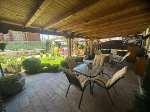 a patio with a table and chairs and a piano at NIKI HOUSE in Bansko