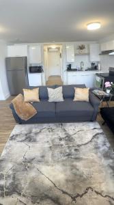 a living room with a blue couch and a kitchen at Luxury Suite in Bristol Riverview in Riverview +45 photos