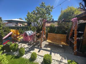 a garden with a wooden bench and a playground at NIKI HOUSE in Bansko