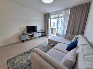 a living room with a couch and a tv at Entrez Apartment Mlynská Bašta – Košice old center in Košice