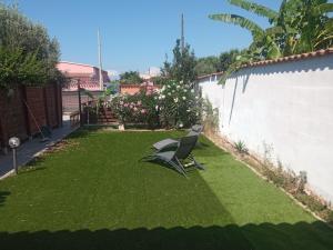 a chair sitting on the grass in a yard at Luce di Mare in Quartu SantʼElena