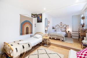 1 dormitorio con 2 camas y un arco iris en la pared en GuestReady - Designer Stay in Boho Batignolles, en París