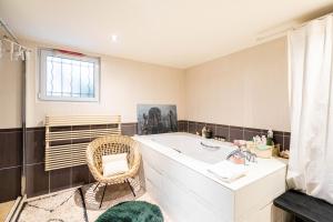 y baño con bañera y silla. en GuestReady - Designer Stay in Boho Batignolles, en París 20 fotos más