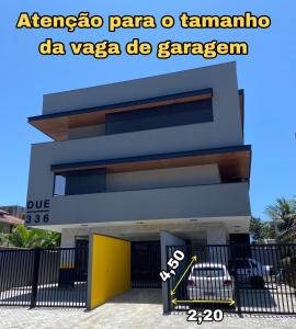a building with a yellow door in front of it at Loft moderno próximo a Praia Grande e Centro Turístico in Ubatuba +20 photos
