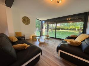 a living room with two couches and a large window at Gîte des Tamaris Maison Chaleureuse proche Circuit in Arnage