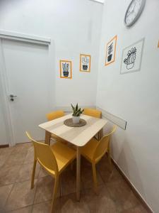 a table and chairs in a room with a clock on the wall at Da Linda Appartamento in Livorno