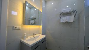 a white bathroom with a sink and a mirror at 4 Mevsim Konak in Kartepe