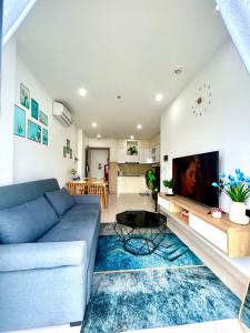 un salon avec un canapé bleu et une télévision dans l'établissement Tom's House 2 Apartment, à Thôn Văn Dương