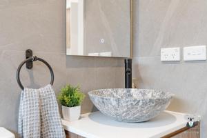 a bathroom with a bowl sink and a mirror at KozyGuru | Cobbitty | Cozy One-Bedroom Retreat in Cobbitty +7 photos