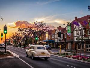 an old car is driving down a city street at KozyGuru | Cobbitty | Cozy One-Bedroom Retreat in Cobbitty