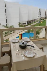 a table with plates and utensils on it with a view of a pool at Porto Said Family Spot in Port Said