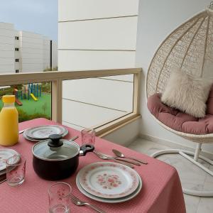 a table with a pink table cloth with a pot and plates at Porto Said Family Spot in Port Said
