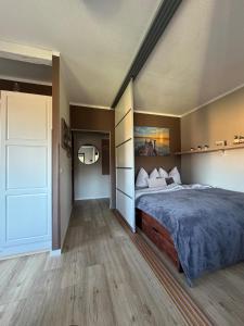 a bedroom with a large bed and a door at Happy Place am Plauer See in Zislow