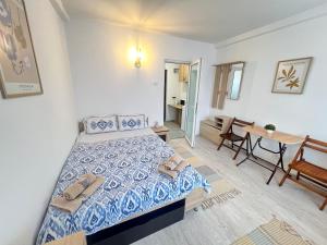 a small bedroom with a bed and a table at Urban LowCost in Văleni +7 photos