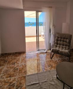 een woonkamer met een bank en uitzicht op de oceaan bij Casa Polita in Castillo del Romeral