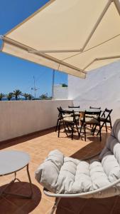 een kamer met stoelen en tafels en een grote parasol bij Casa Polita in Castillo del Romeral