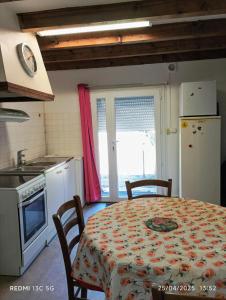 a kitchen with a table and chairs and a kitchen with a table and a refrigerator at Appartement charmant à Le Vigan avec terrasse in Le Vigan
