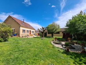 a house with a yard with a grass field at LA BARAQUE in Courtois-sur-Yonne