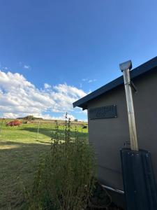 a sign on the side of a building next to a field at Umtshitshi Camp Site in Himeville