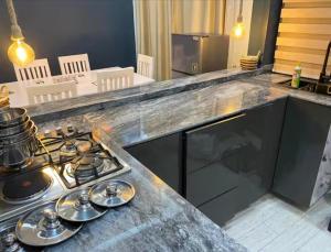 a kitchen with a stove top oven next to a counter at Beverly homes Entebbe in Kitubulu