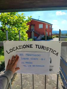 a person holding up a sign in front of a building at Ca' dei Berici - Relax tra Colli e città d'arte in Grancare
