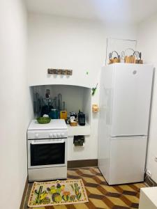 una cucina con fornelli e frigorifero bianco di Domus Olea & Opuntia Salento a Galatone