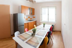 a kitchen with a table with chairs and a refrigerator at Hradní Ubytování in Hněvětice