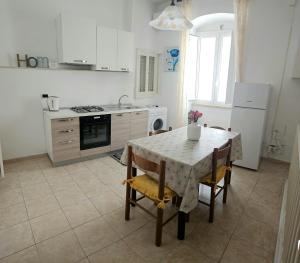 a kitchen with a table and chairs and a kitchen with a stove at Casa Aurora in Polignano a Mare