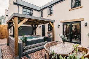 a patio with a hot tub and a wooden pergola at South Causey Inn in Stanley