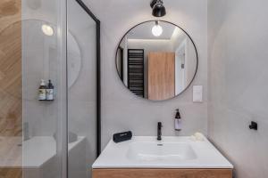 een badkamer met een wastafel en een spiegel bij Cozy Corner by Cozyplace in Krakau +41 foto's
