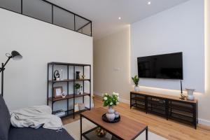 een woonkamer met een bank en een tv bij Cozy Corner by Cozyplace in Krakau