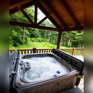 a hot tub on the deck of a cabin at Evergreen - by The Chalets in Laurelville