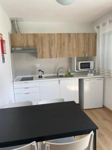 a kitchen with white cabinets and a black table at Campimeco by Campigir in Alfarim