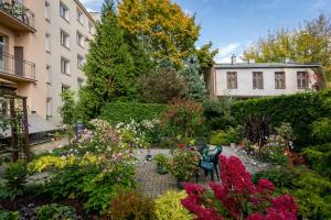 een tuin met kleurrijke bloemen en een gebouw bij Cozy Corner by Cozyplace in Krakau